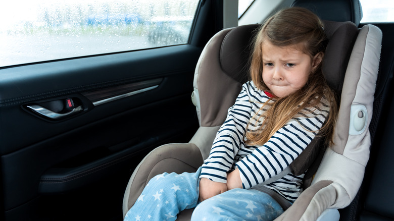 little girl needing to pee while in a carseat