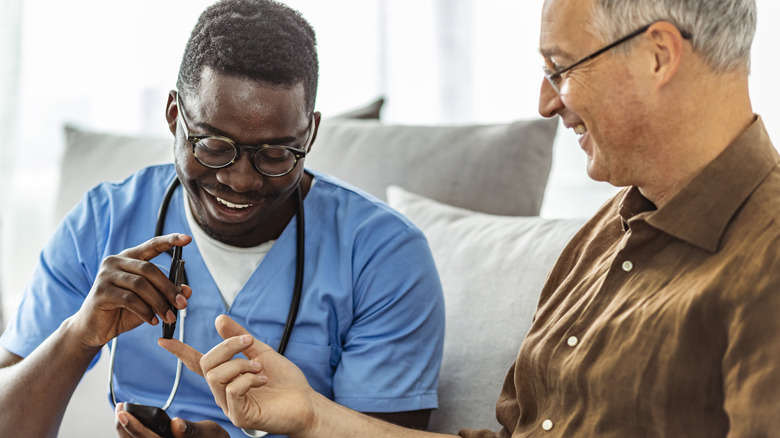 Healthcare professional checking patient blood sugar