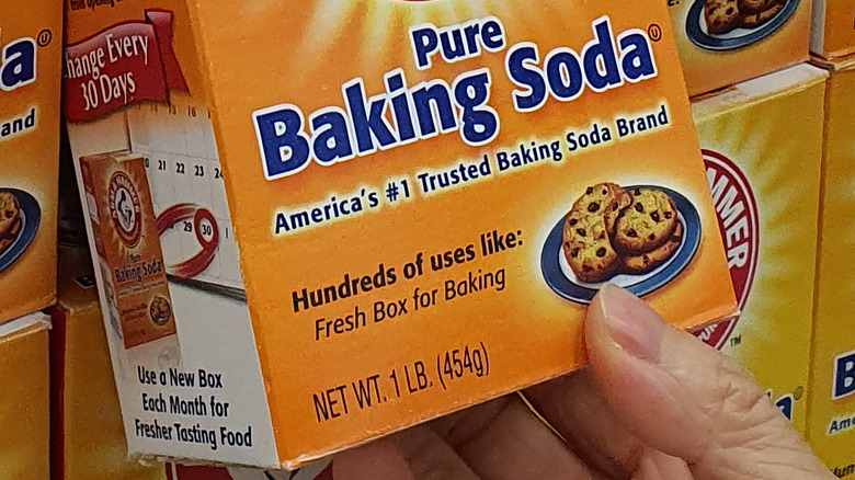 Person buying baking soda at supermarket