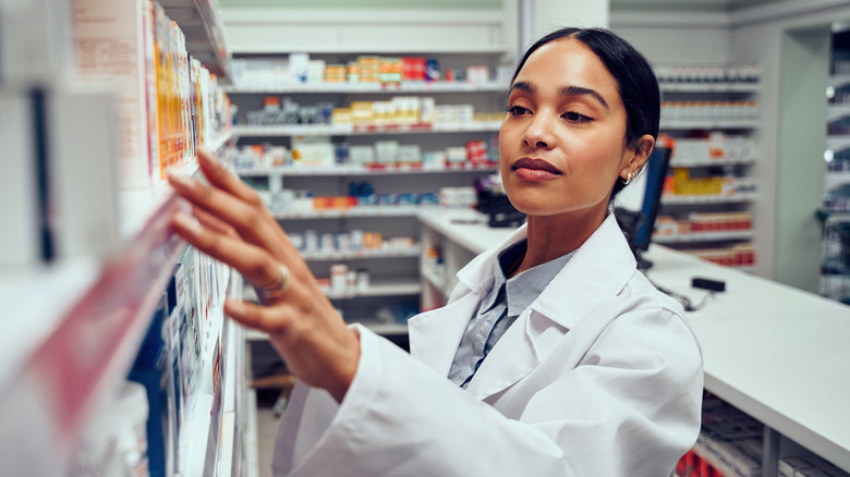 pharmacist organizing drugs on shelf