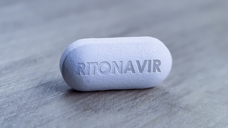 Ritonavir pill representation on periwinkle backdrop