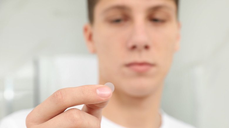 Teenager holding pimple patch
