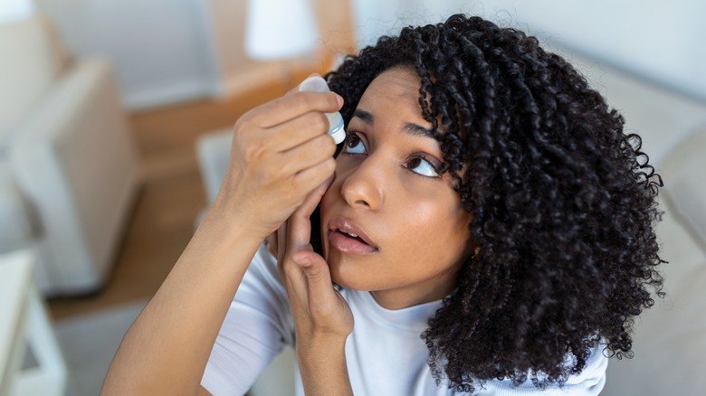 Woman putting in eyedrops