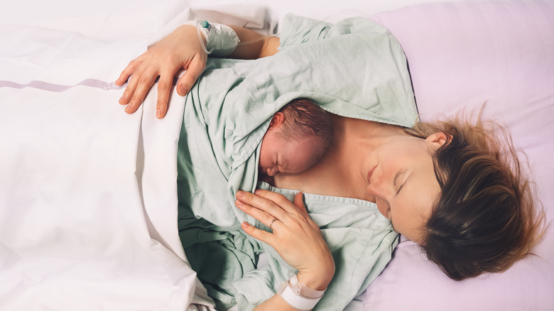 overhead view of mom in hospital bed with newborn baby on her chest