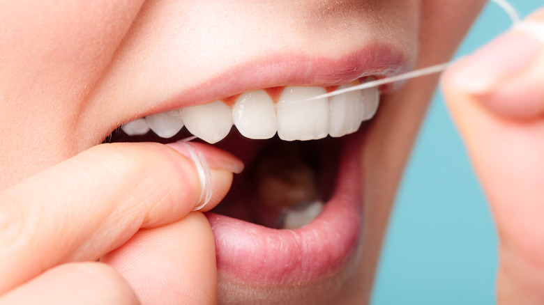 woman flossing teeth