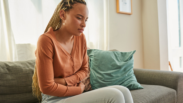 Woman hugging stomach in pain