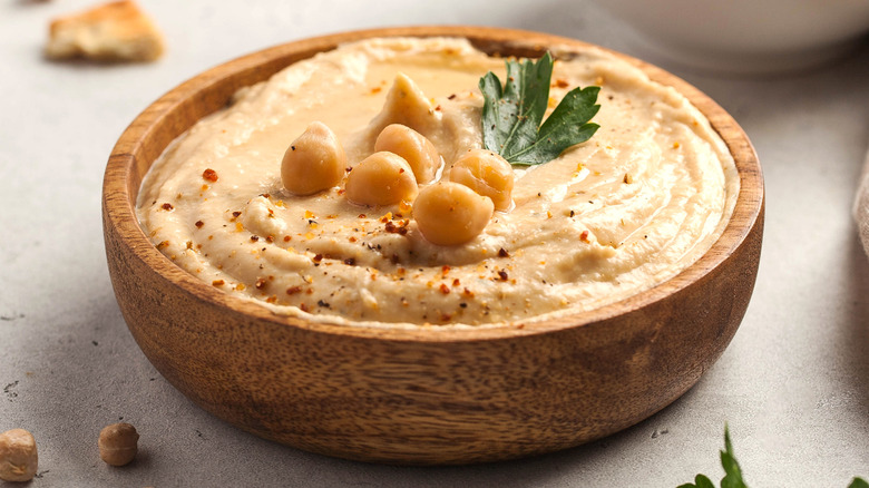 A wooden bowl of fresh hummus