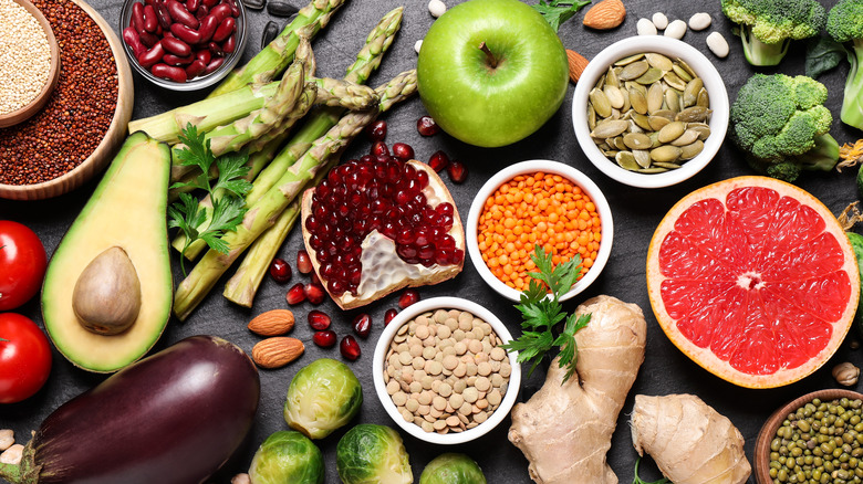 Fruits, vegetables, nuts, and seeds against a gray background 