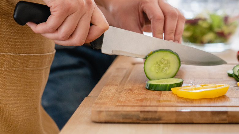 person chopping vegetables on cutting board