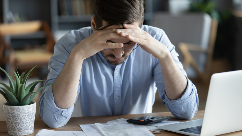 Man looking at his bills showing debt