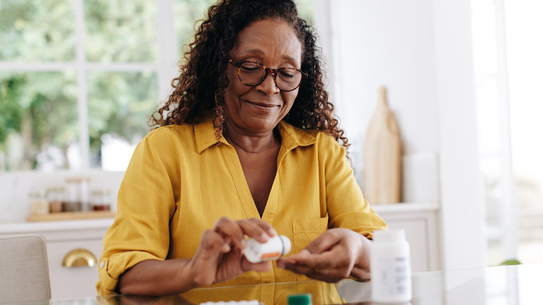 Woman pouring out medication into hand