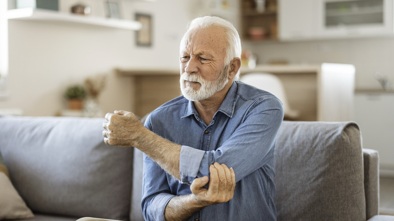 man with gout holding elbow