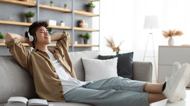 Man relaxing on couch listening to headphones