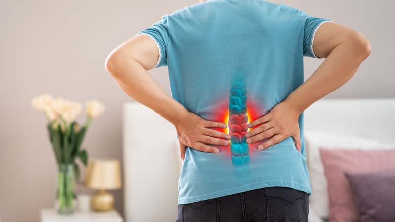 Person holding back with red spine graphic on lower back