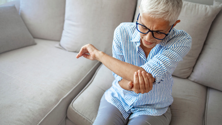 Woman in pain holding elbow