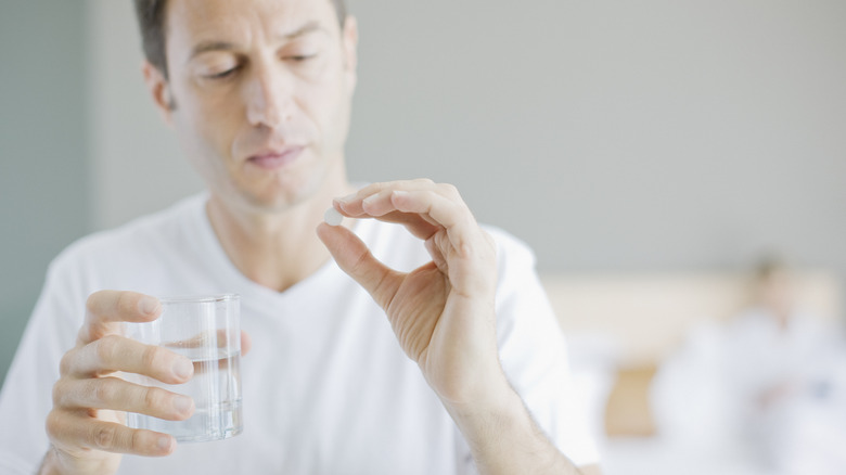 Man with asprin tablet and glass of water