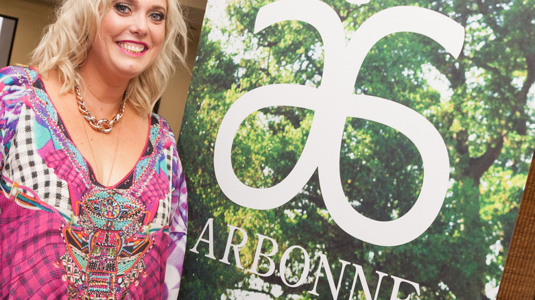 woman next to arbonne standee