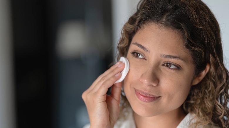 Woman applying toner with cotton pad