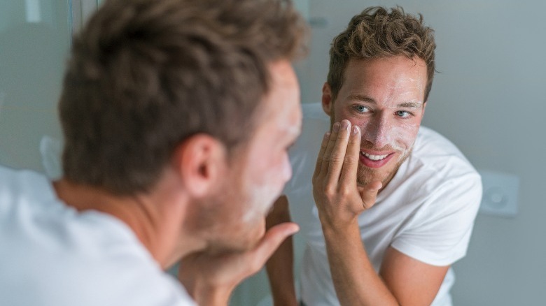 Man using exfoliating facial scrub