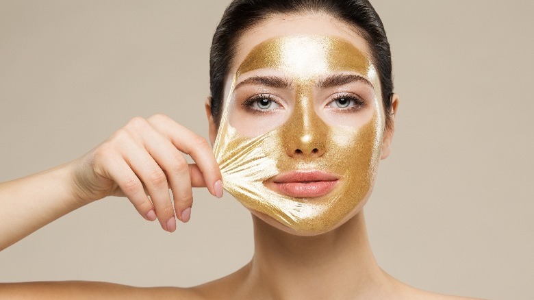 Woman peeling off facial mask