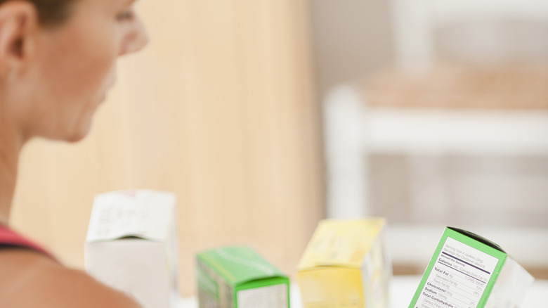 woman reading food label on boxed product