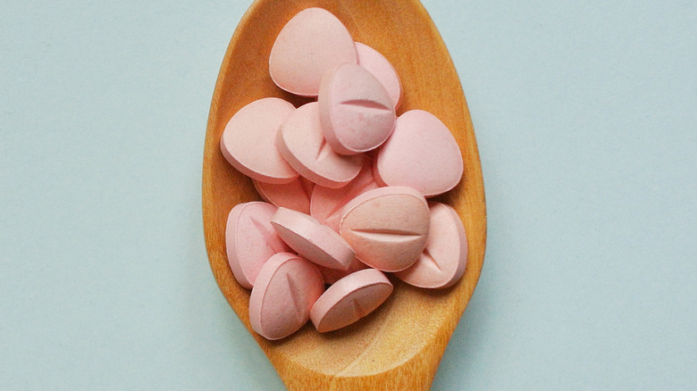 wooden spoon with pink vitamins