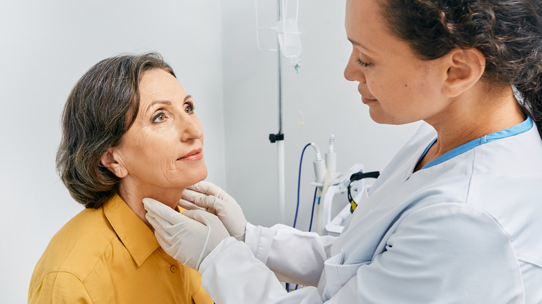 Doctor checking woman's neck