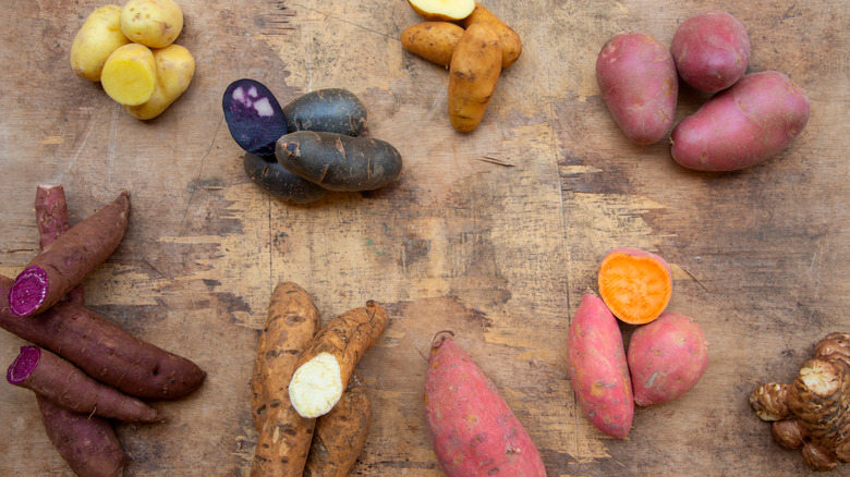 Different types of potatoes on wood surface