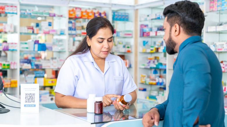 pharmacist showing medication to customer