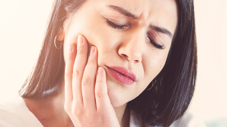 woman holding mouth from tooth pain