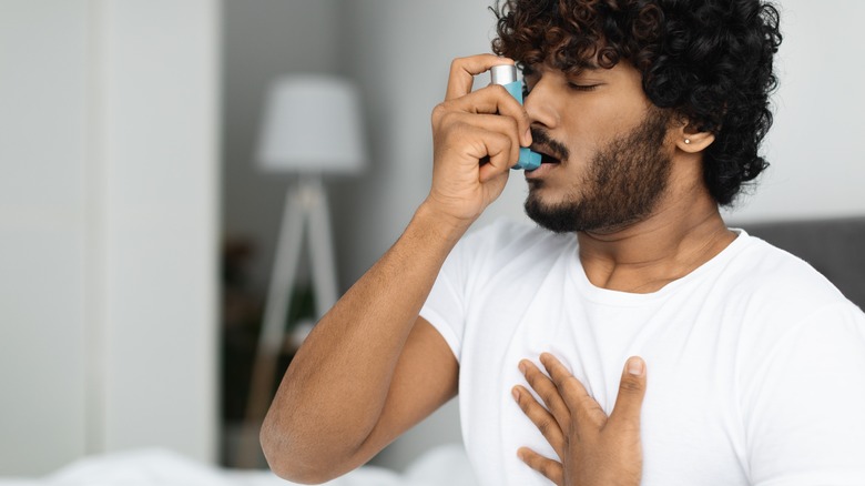 man using an inhaler 