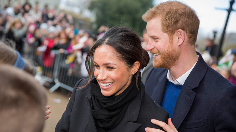 Prince Harry and Duchess Meghan smiling together in 2018