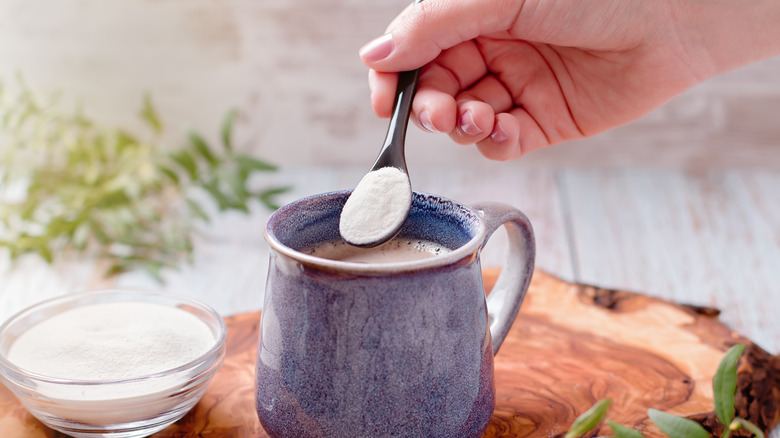 Hand adding powder to coffee