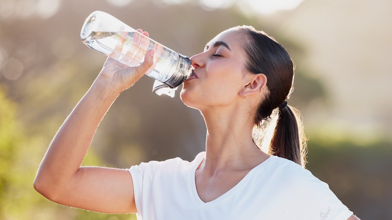 Woman drinking water while outside