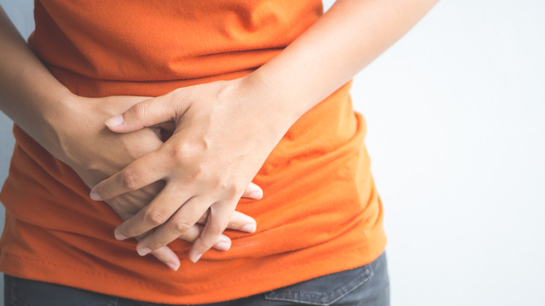 woman holding her stomach in pain