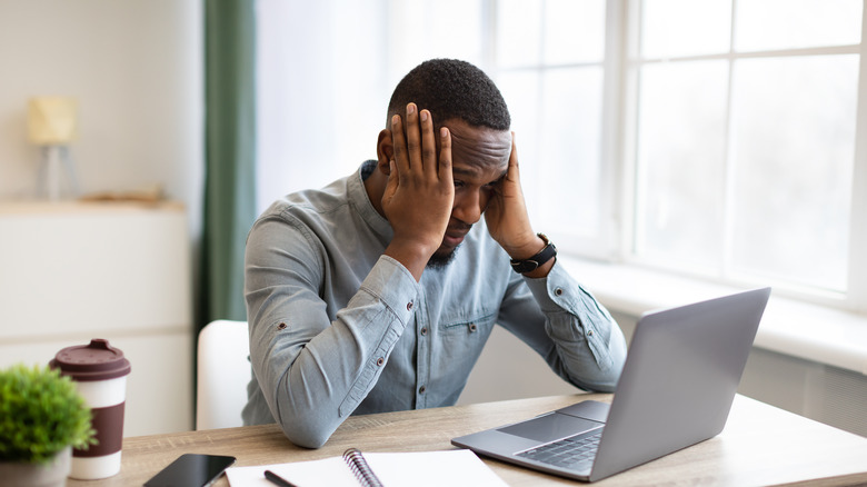 man stressed out looking at laptop