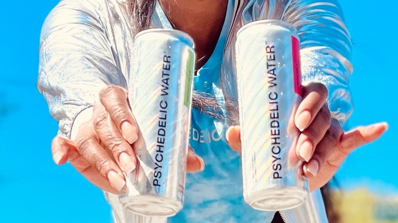 woman holding Psychedelic Water cans