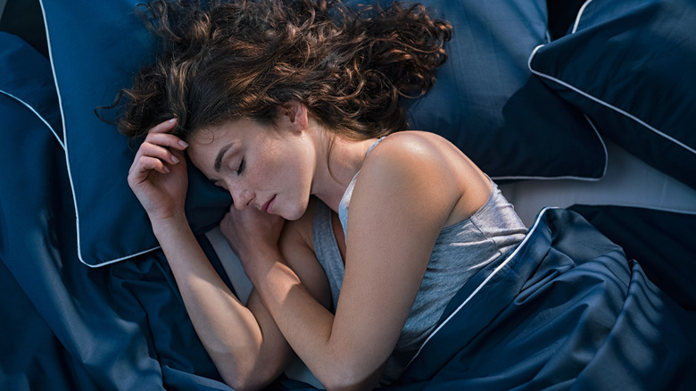 a young woman sleeping in bed 