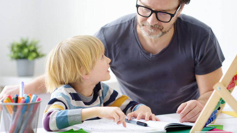 man doing schoolwork with child