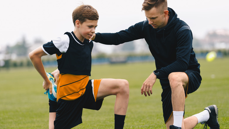 Coach and young athlete on field