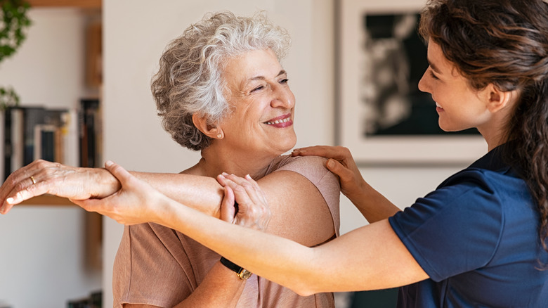 Trainer helping a woman stretch