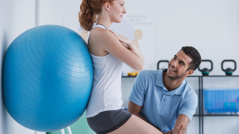 Trainer guiding client while exercising