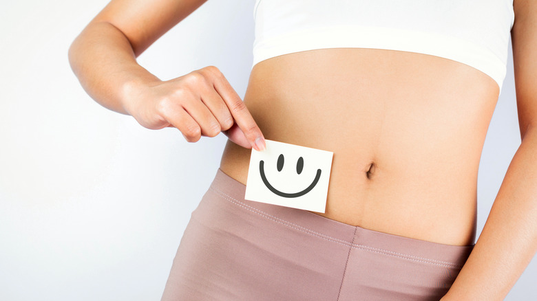 Woman holding smiley face image