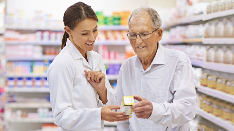 Pharmacist showing man medication