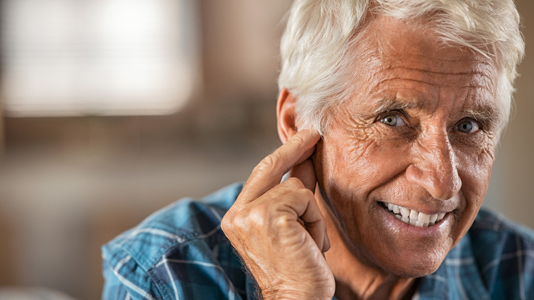 senior man touching his ear