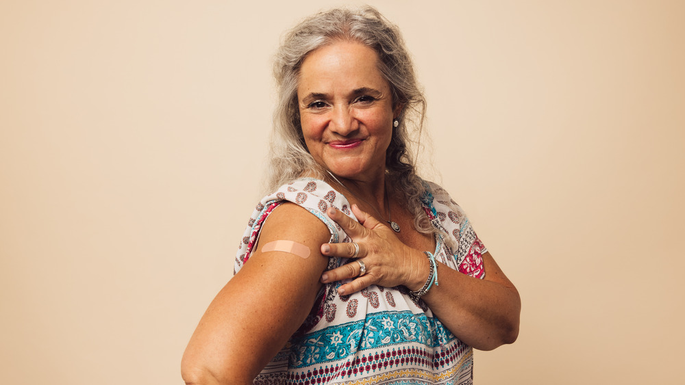 Older woman smiling with band-aid on arm