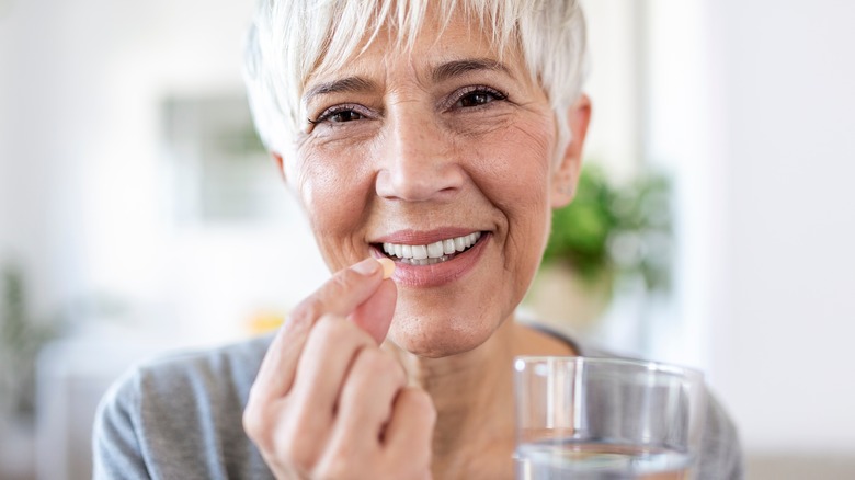 woman with white hair taking medication
