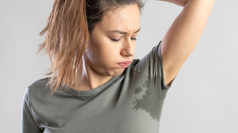 Woman wearing T-shirt sweating underarms