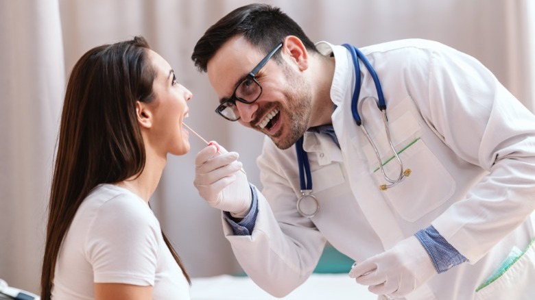 doctor swabbing patient's throat