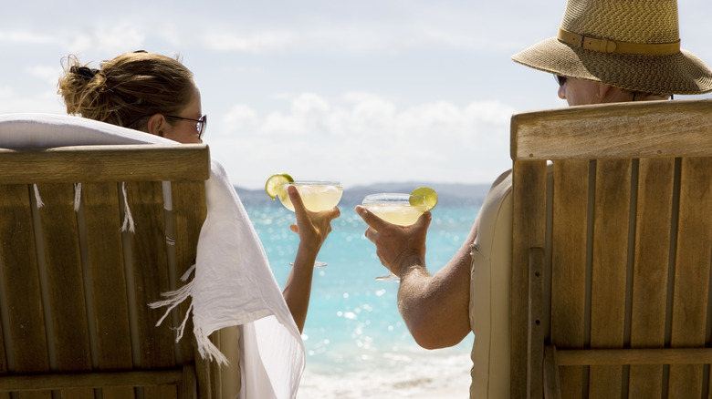 couple drinking margaritas on beach